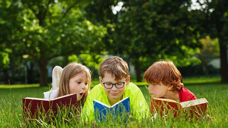 Cute,Children,Reading,Colorful,Books,Together,Outside,In,The,Park.